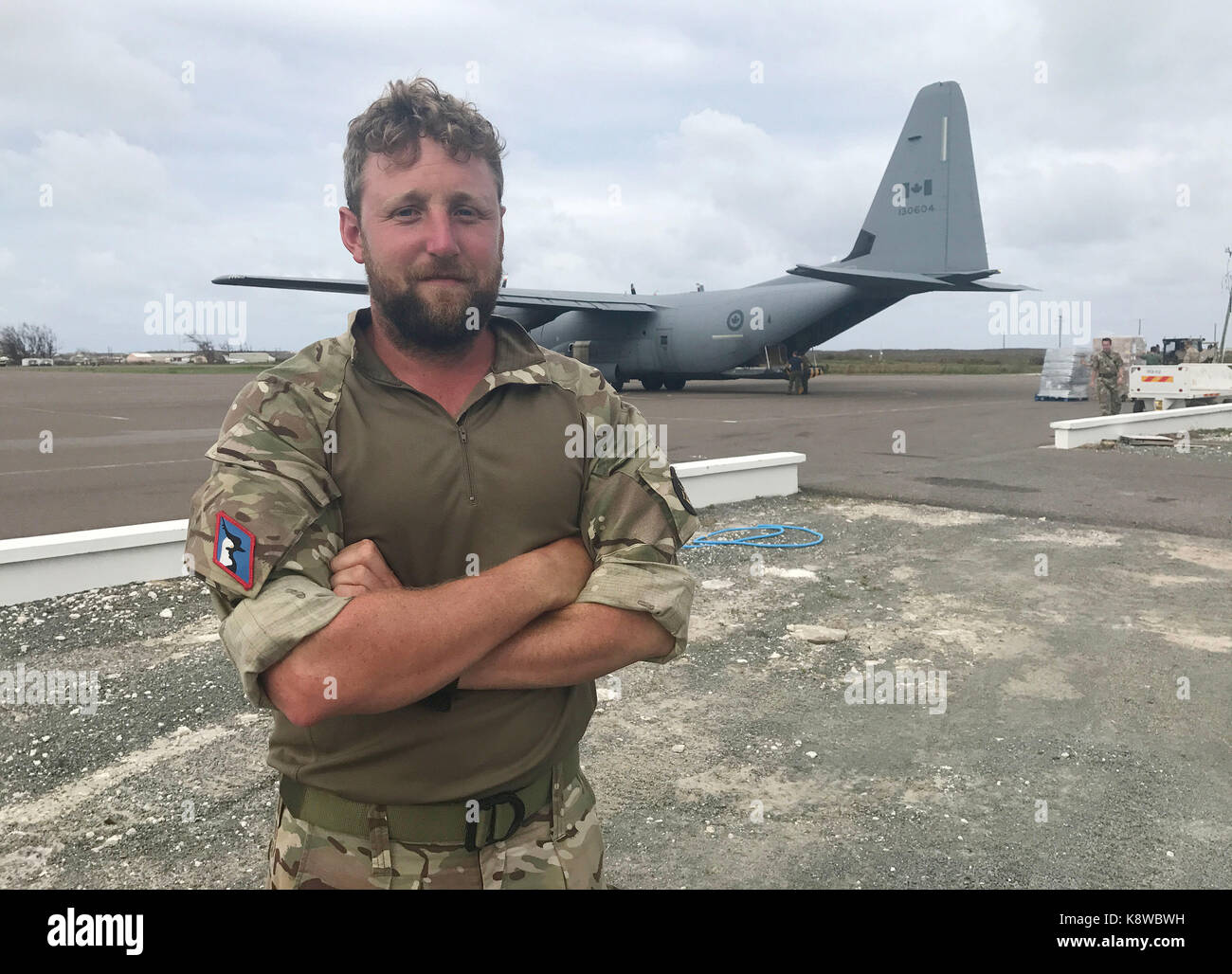 Royal Navy Lieutenant Stephen Dunning stands in front of a Royal Canadian Air Force Hercules aircraft. A final aid drop has landed on a British overseas territory ahead of Hurricane Maria's arrival, as residents stress a second storm is the last thing they need. Stock Photo