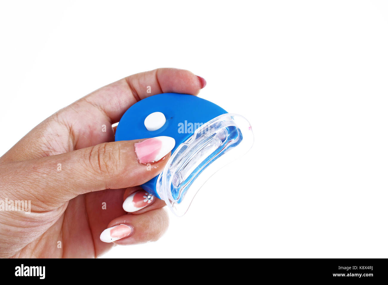 Teeth whitening home kit LED lamp uv light in woman's hand. Stock Photo