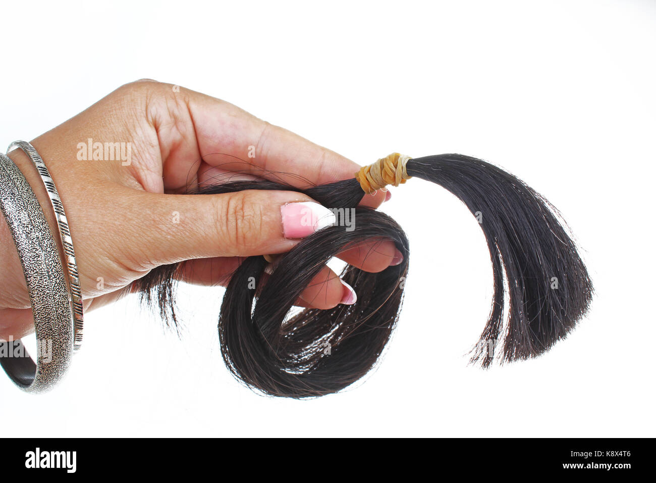 Human hair. Hair cut for hair extension.  Cutted black long hair tail. Stock Photo