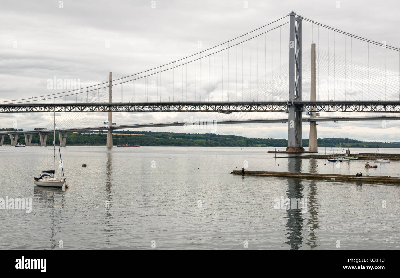 View of Forth Road Bridge and new Queensferry Crossing from North Queensferry with sailboat in foreground, North Queensferry, Fife, Scotland, UK Stock Photo
