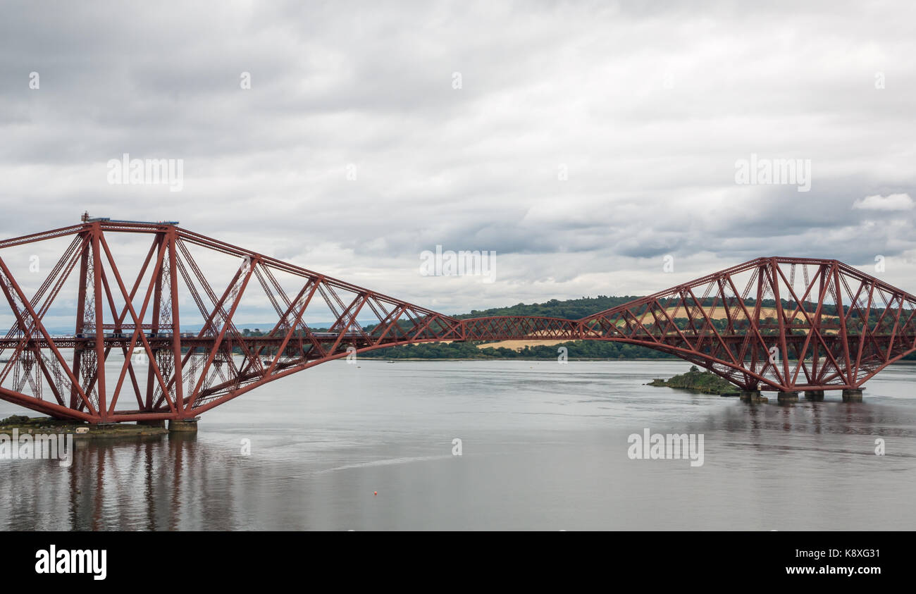 View of two carriage local ScotRail train on cantilever Forth Rail Bridge with calm water, Firth of Forth, Scotland, UK Stock Photo