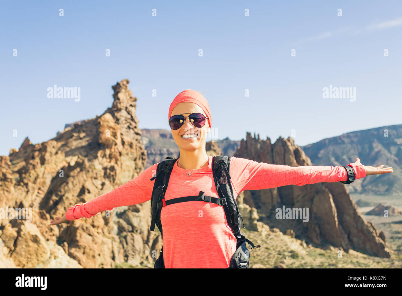 Hiking or climbing success with arms raised concept. Female runner or