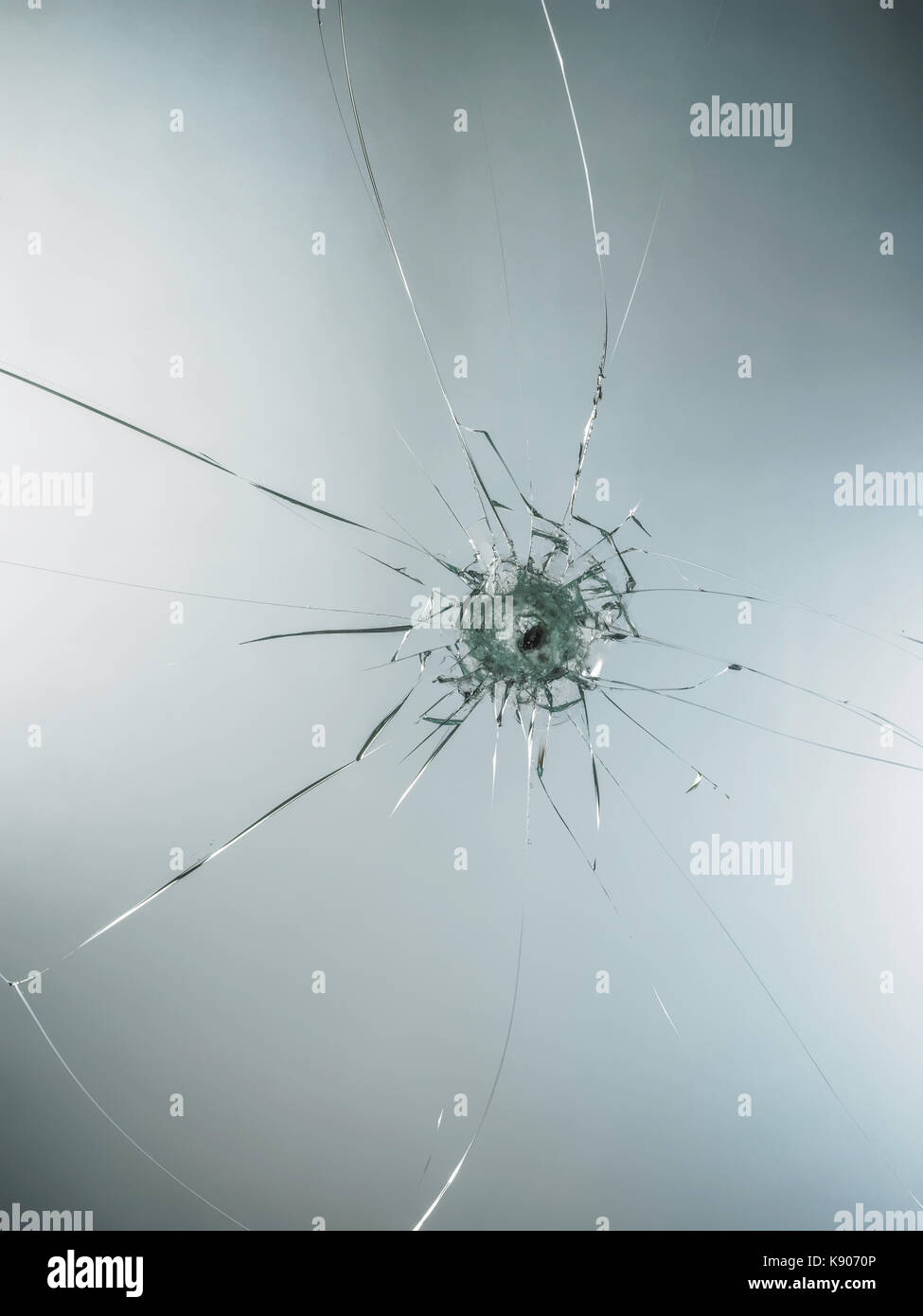 Bullet Hole in glass isolated on white background. Stock Photo