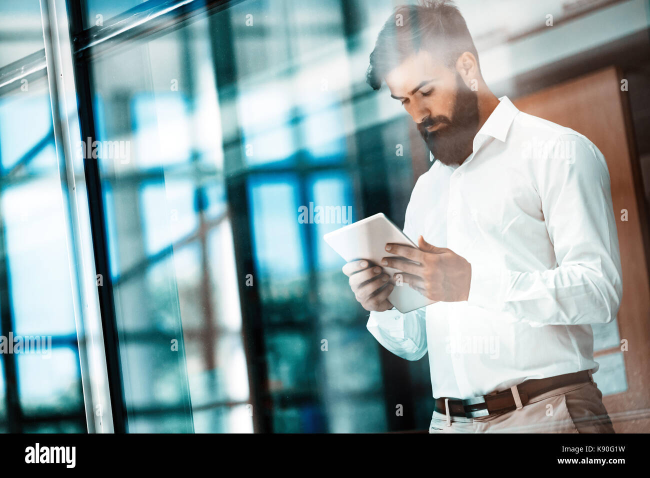 Handsome young businessman using his digital tablet Stock Photo