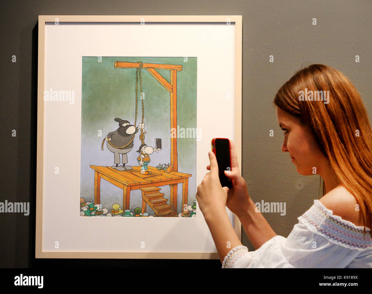 Oberhausen, Germany. 21st Sep, 2017. A woman takes a picture of an untitled comic illustration (Majorca 2015) by Guillermo Mordillo pictured at the Ludwig Gallerie Schloss Oberhausen in Oberhausen, Germany, 21 September 2017. The Ludwiggalerie is showing more than 150 originals and prints to mark the artist's 85th birthday, from 24 September 2017 to 07 January 2018. Credit: Roland Weihrauch/dpa/Alamy Live News Stock Photo
