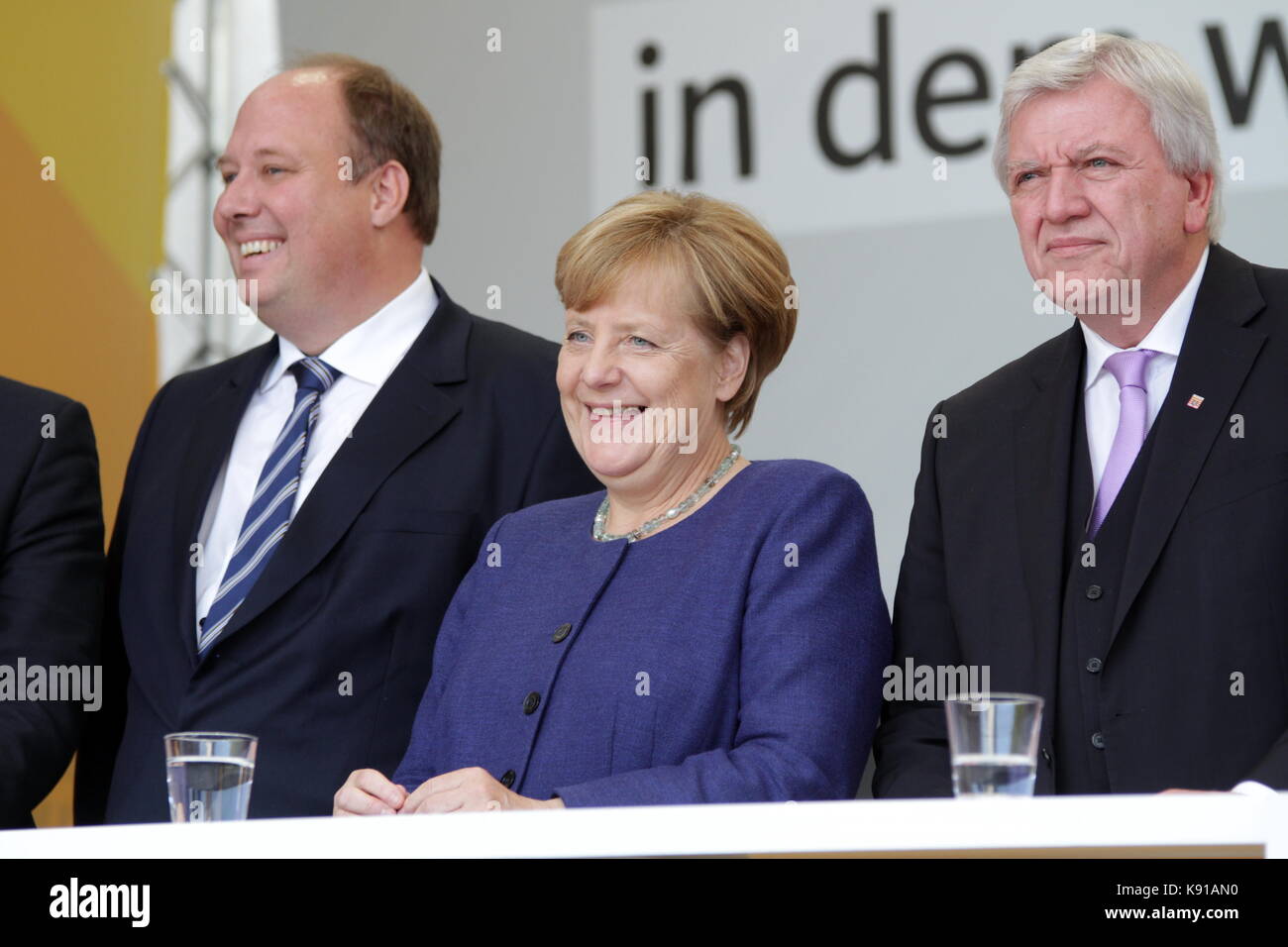 Giessen, Germany. 21st September, 2017. Angela Merkel, Chancellor of Germany holds an election campaign speech as leader of the Christian Democratic Union and leading candidate as federal chancellor  to the federal Bundestag elections (24th Sept 2017) at Brandplatz in Giessen, Germany. Here: Angela Merkel (center) with Helge Braun (left), minister of state at german chancellery, member of parliament and CDU direct candidate of constituency Giessen (173), and Volker Bouffier (right), prime minister of german state Hesse.  Credit: Christian Lademann Stock Photo