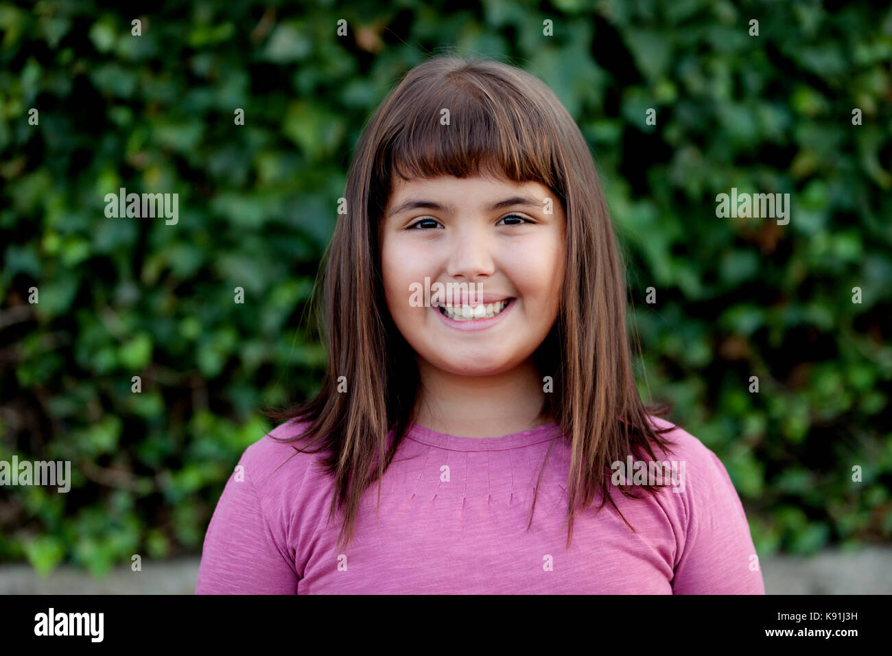 Little preteen girl with pink t-shirt in park Stock Photo - Alamy
