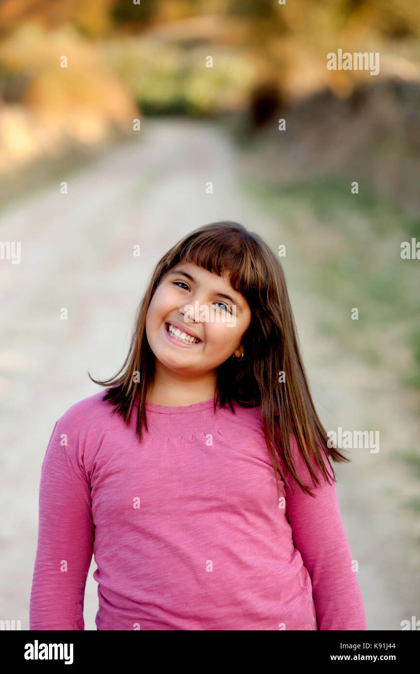Little preteen girl with pink t-shirt in park Stock Photo - Alamy