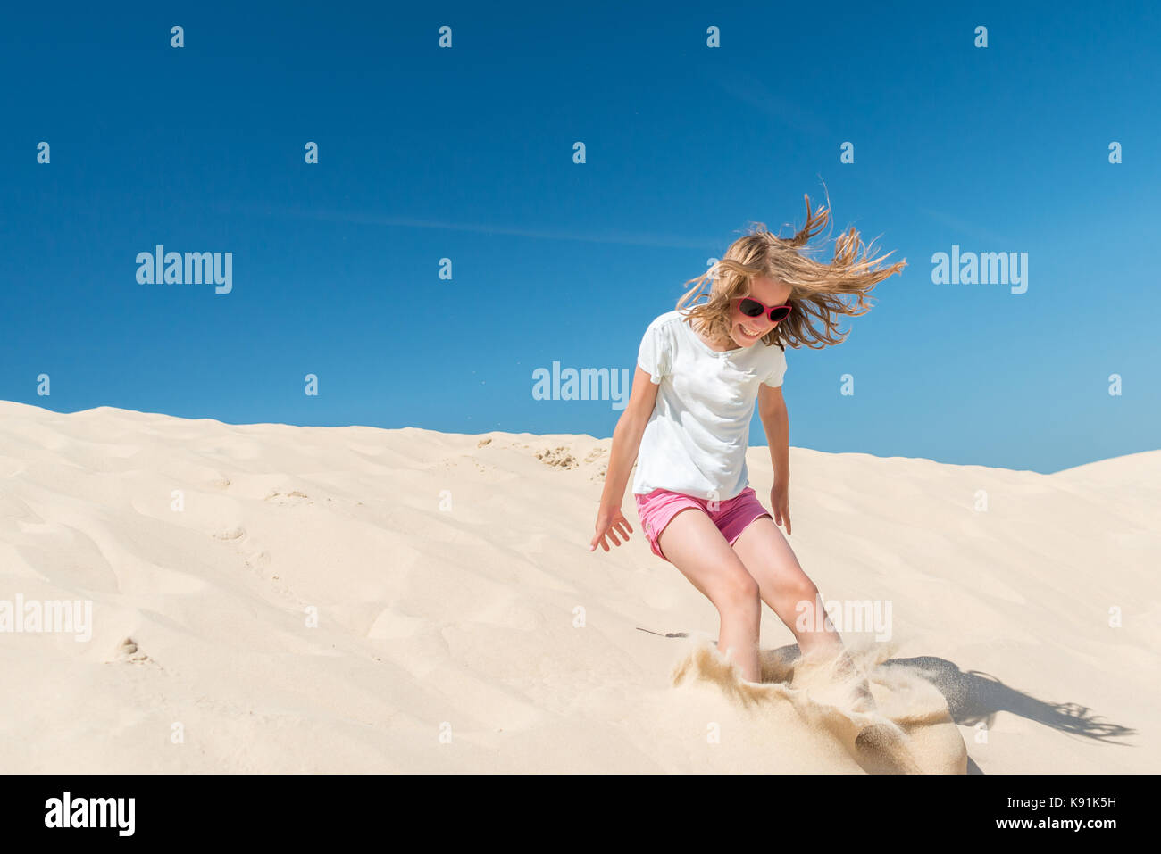 Jumping young girl in front of blue sky Stock Photo - Alamy