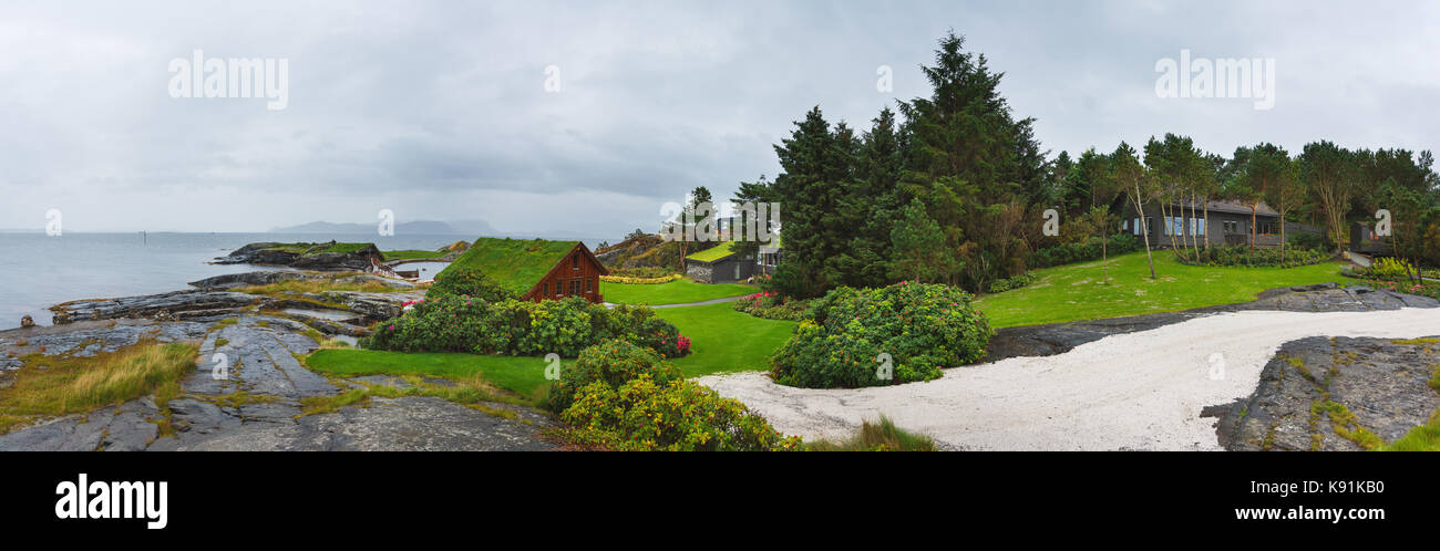 Stavanger, Norway - August 28 2017: Panoramic view of wooden houses on the stony shore in Flor and Flaere garden in inclement weather Stock Photo