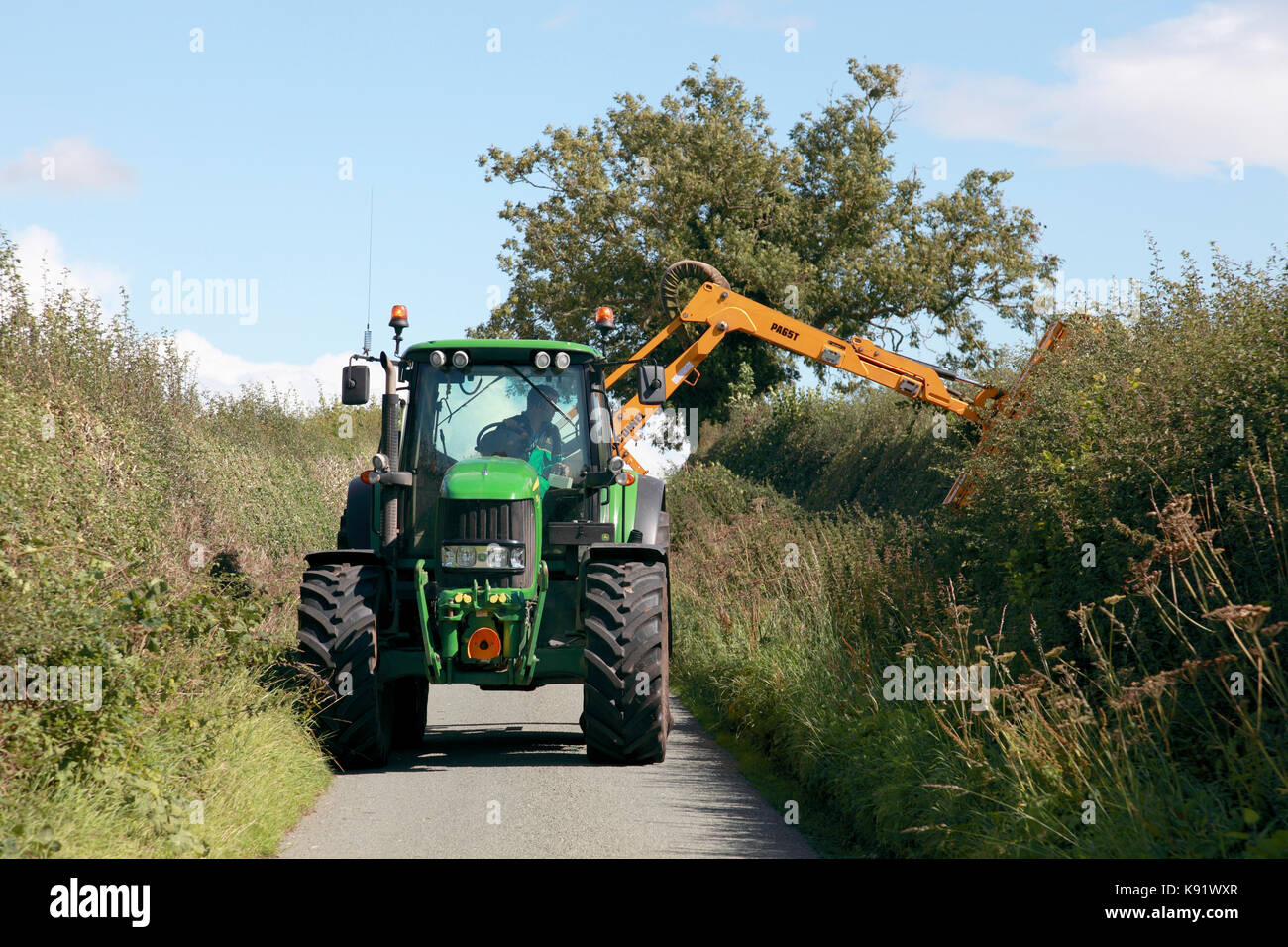Hedge cutting in a narrow country lane in rural Shropshire, England Stock Photo
