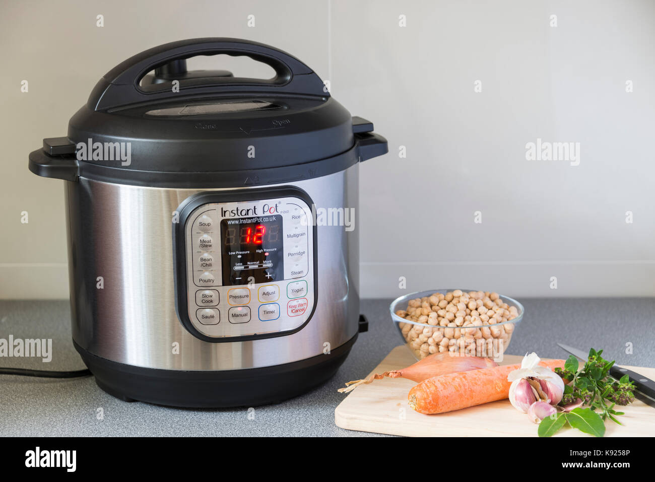 An Instant Pot Electric Pressure Cooker in use in a kitchen. Stock Photo