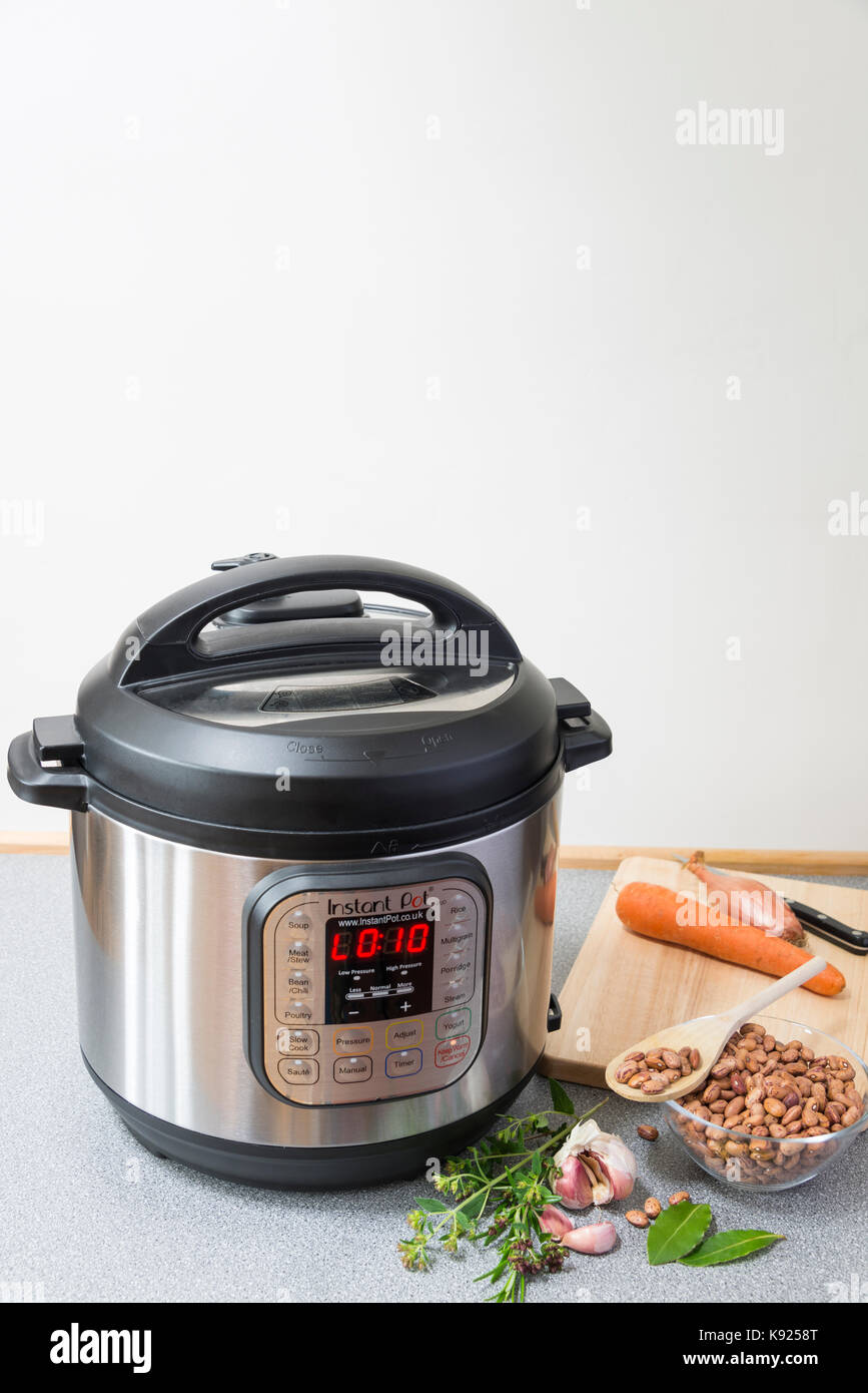 An Instant Pot Electric Pressure Cooker in use in a kitchen. Stock Photo