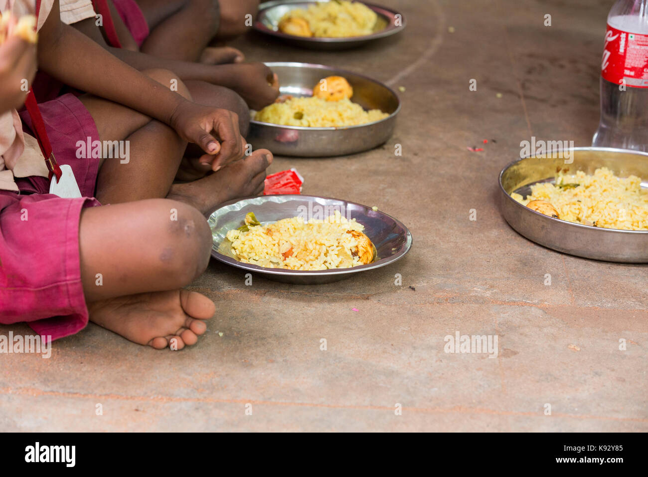 PONDICHERY, PUDUCHERY, INDIA - SEPTEMBER 04, 2017. Unidentified boys girls children sit on the floor with their plate of rice and egg at the lunch tim Stock Photo