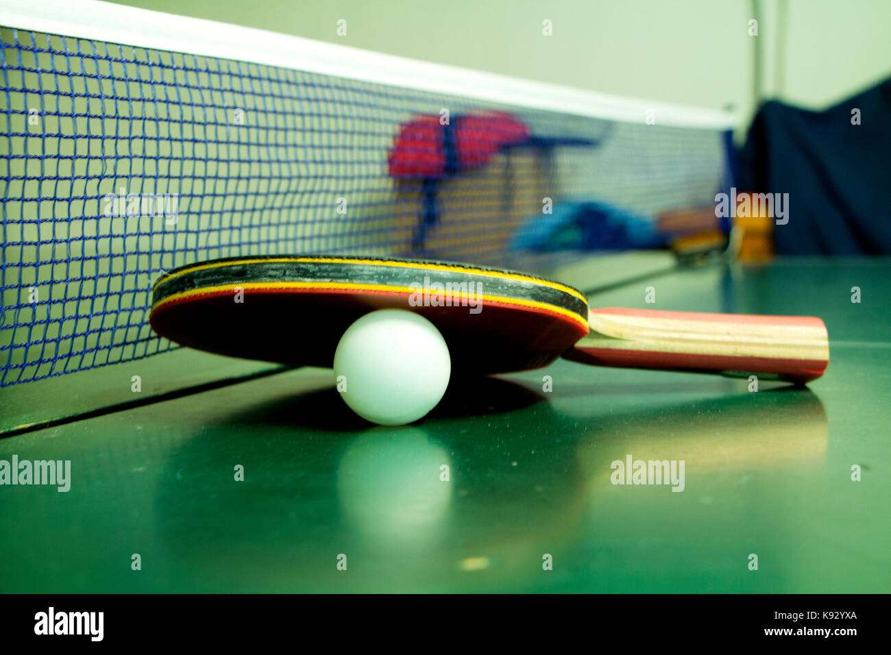 Table tennis racket with white ball on green table Stock Photo - Alamy