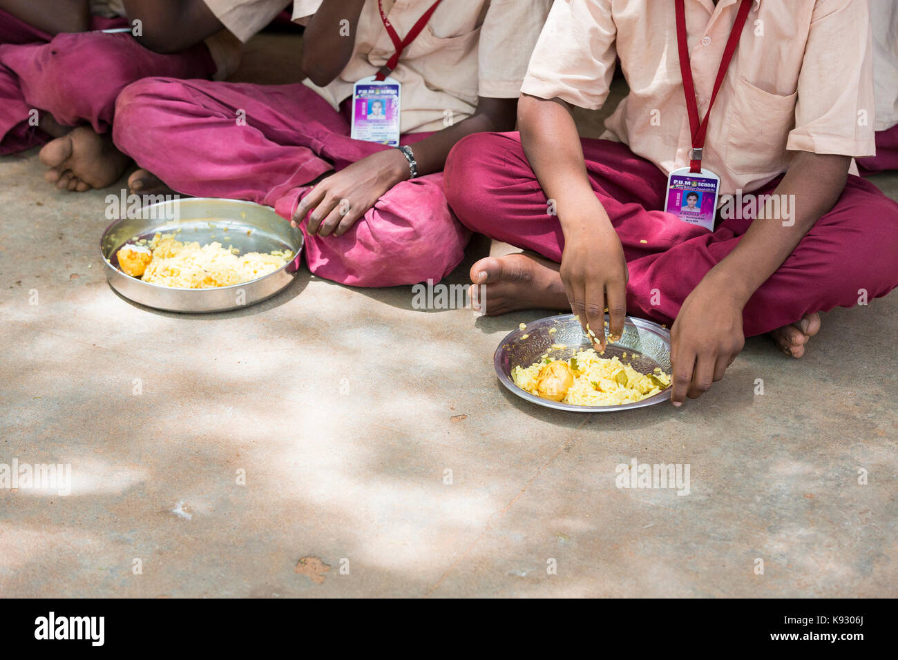 PONDICHERY, PUDUCHERY, INDIA - SEPTEMBER 04, 2017. Unidentified boys girls children sit on the floor with their plate of rice and egg at the lunch tim Stock Photo