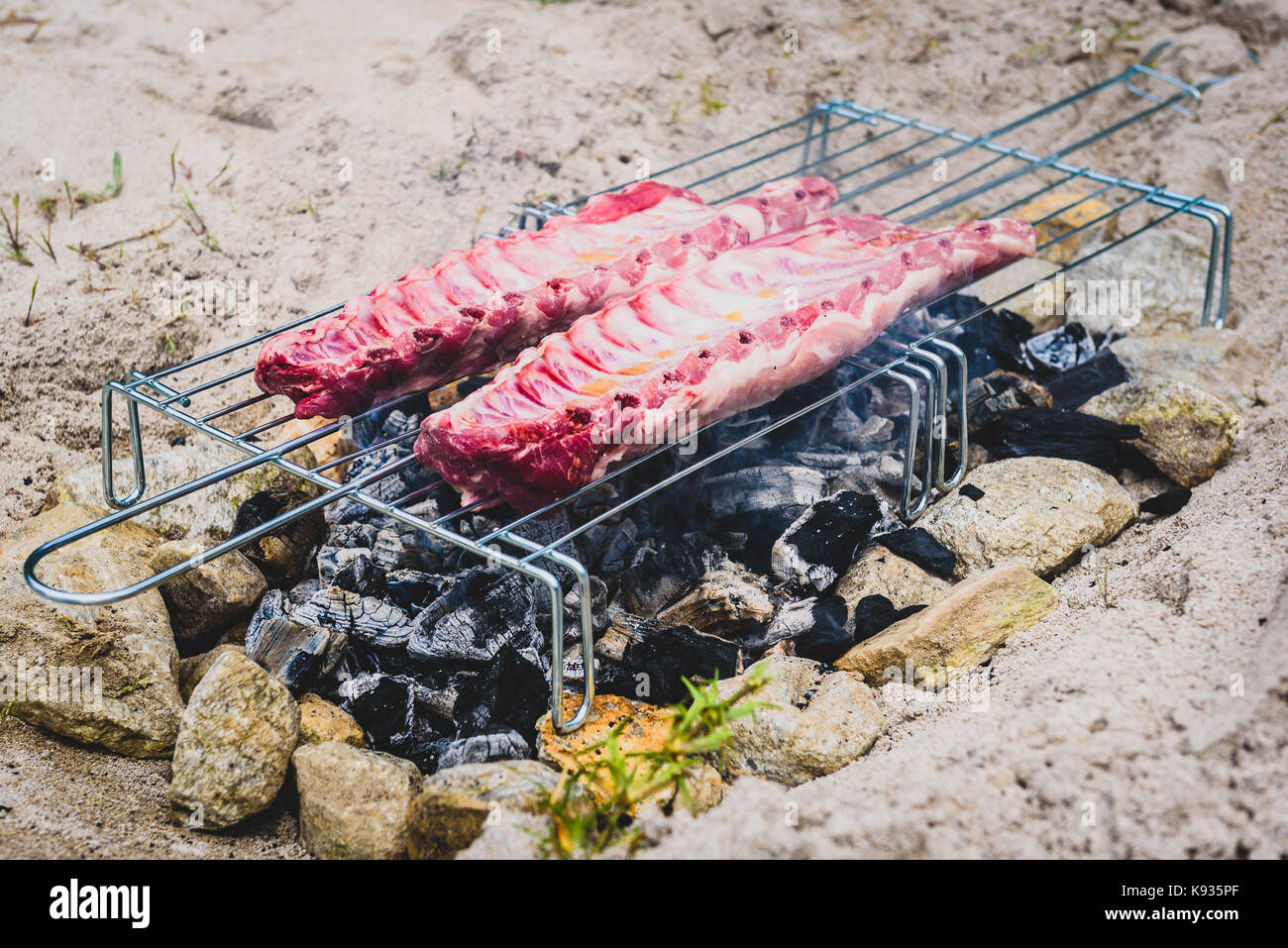 Making pork ribs on homemade improvised BBQ barbecue grill. Making Churrasco on a coal, fire