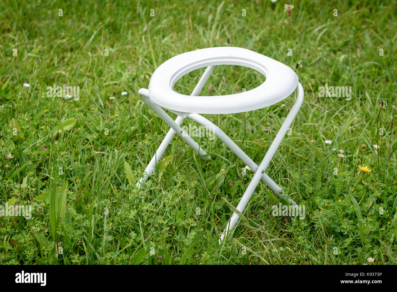 Portable Folding Camp Toilet outdoors in the grass. Camping or motor