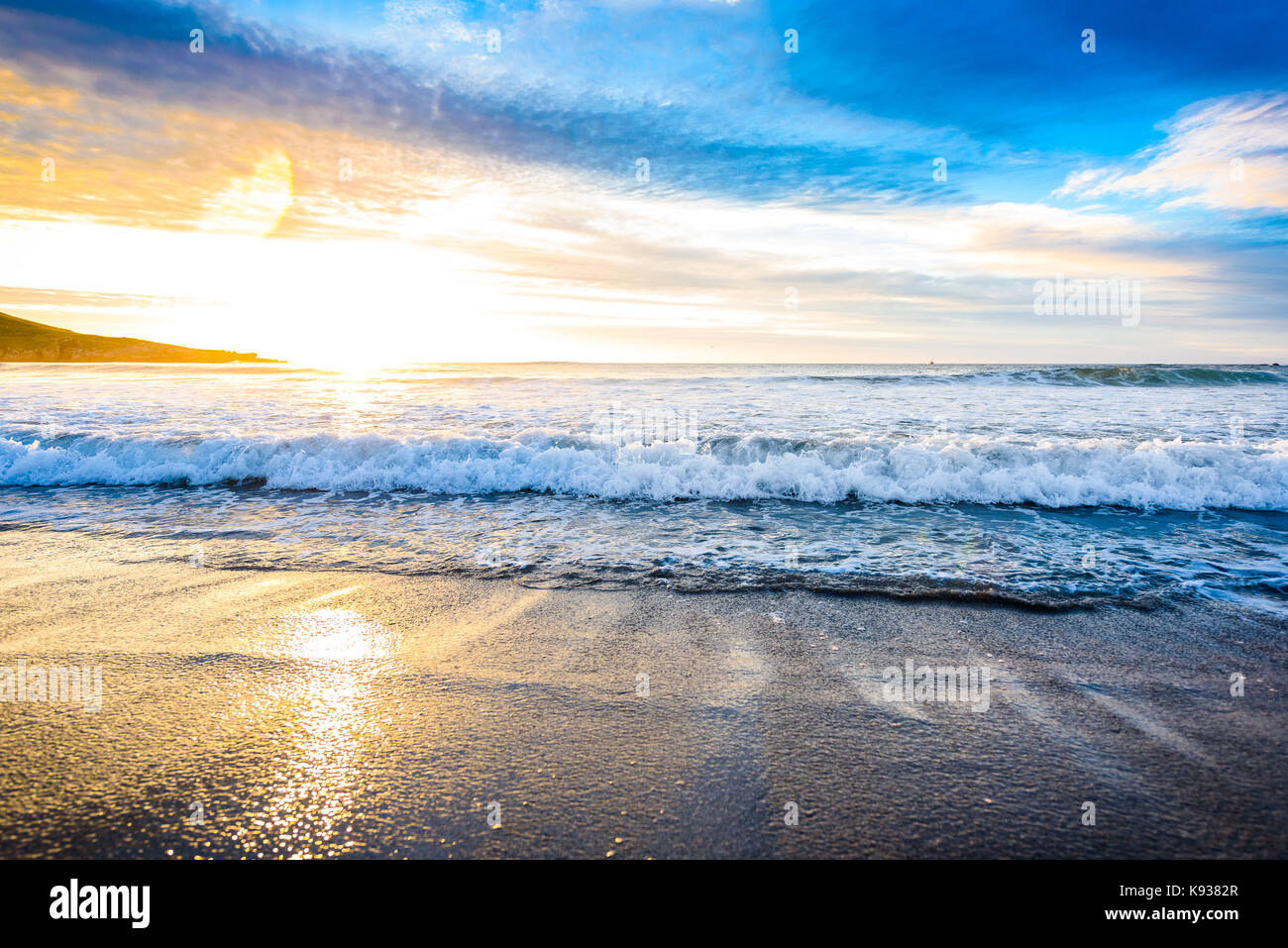 Small ocean sea waves on sandy beach with sunrise sunset. Background