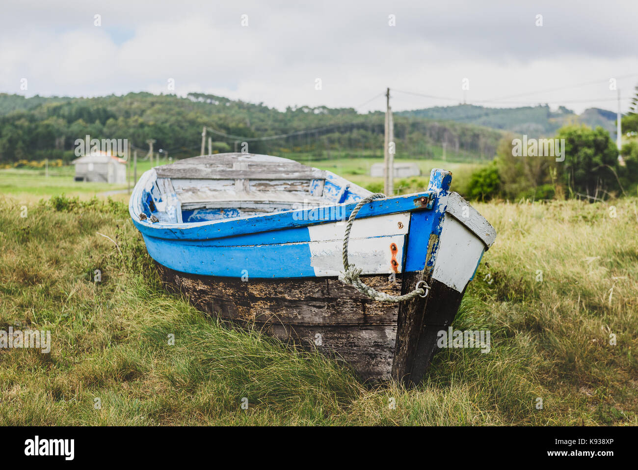 Old abandoned wooden fishing boat stranded on land and grass. Weathered ...