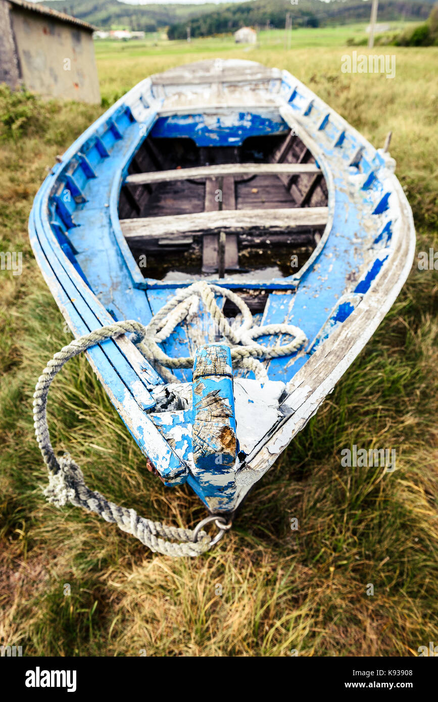 Old abandoned wooden fishing boat stranded on land and grass. Weathered ...