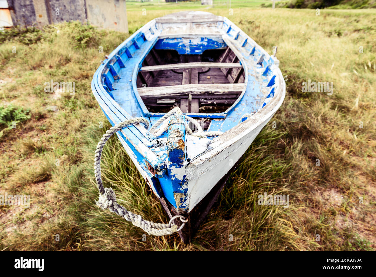 Old abandoned wooden fishing boat stranded on land and grass. Weathered ...