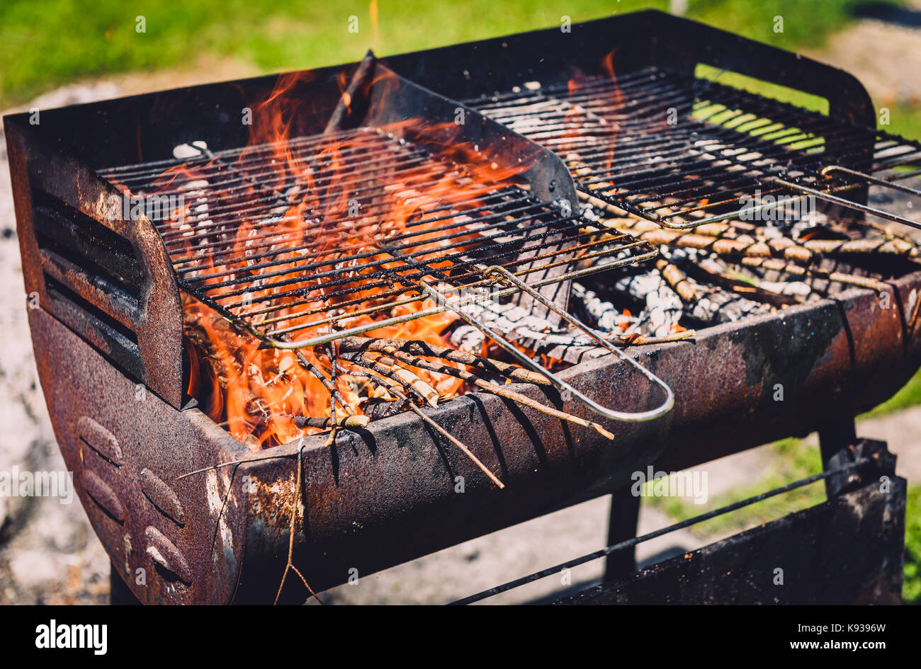 Burning and preheating old rusty barbecue grill cleaning dirty grid. Flames  in bbq in nature - outdoors picnic. Preparing the barbecue for charcoal on  Stock Photo - Alamy