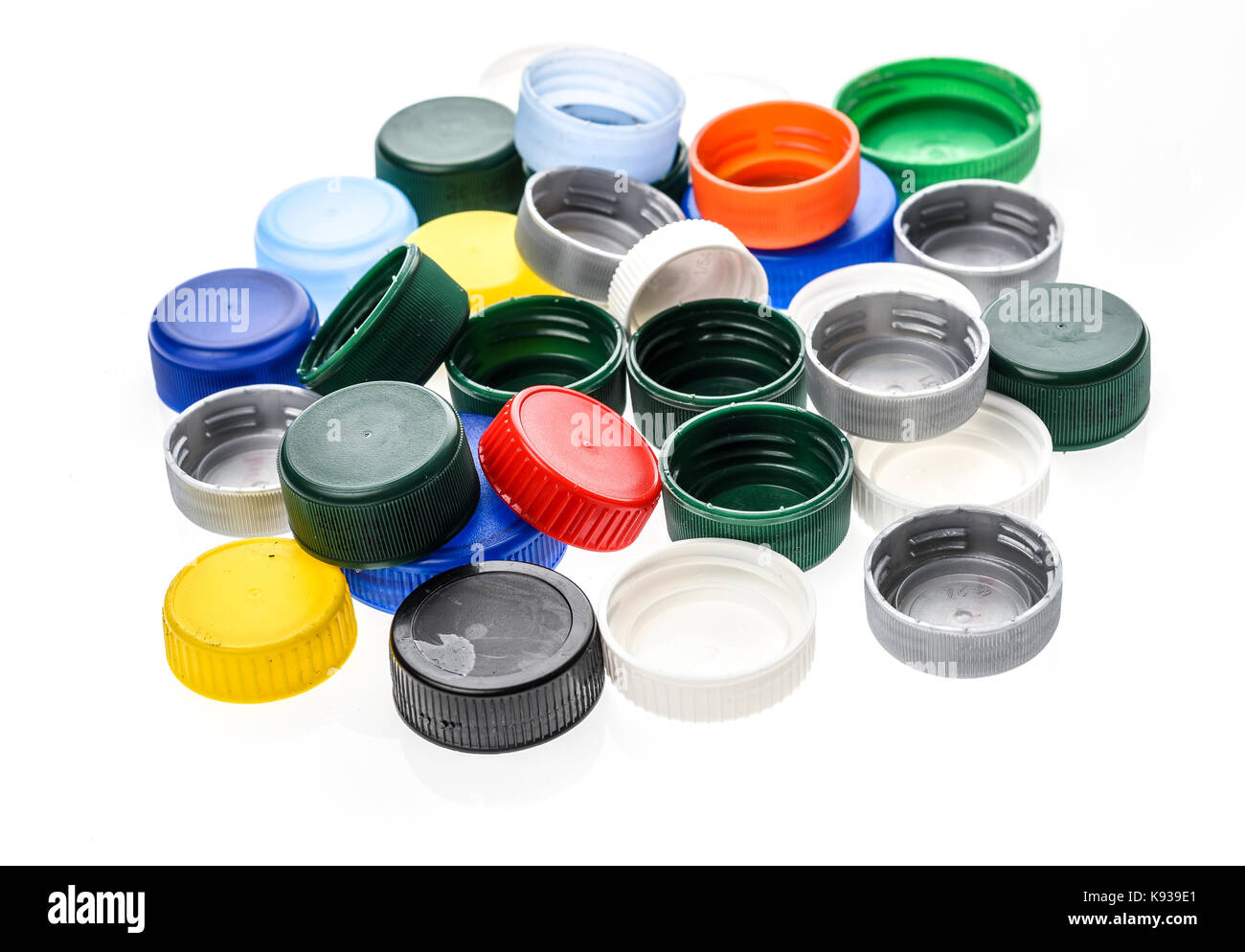 Plastic bottle caps in different colours. A pile of plastic bottle covers. Isolated on white background. Stock Photo