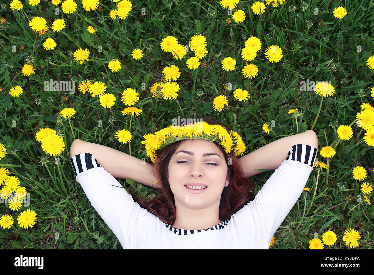 girl resting on a sunny day in meadow of yellow dandelions Stock Photo ...