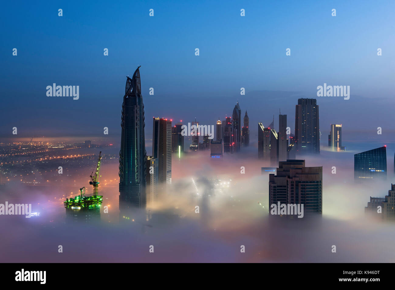 View of illuminated skyscrapers above the clouds in Dubai, United Arab