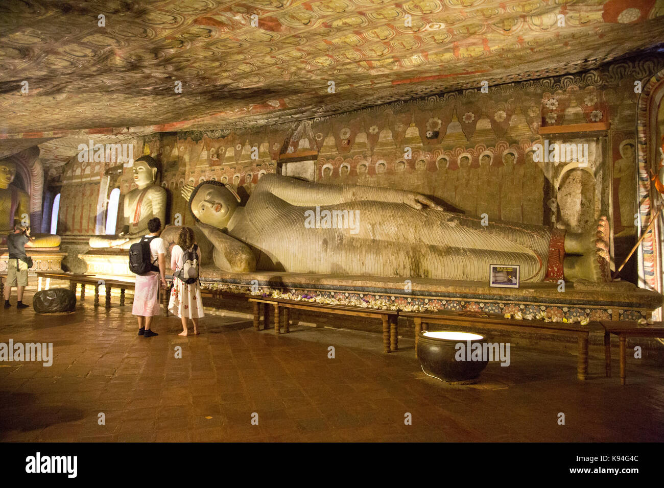 Dambulla Sri Lanka Dambulla Cave Temples - Cave II  Maharaja Viharaya Visitors Looking At Reclining Buddha Stock Photo