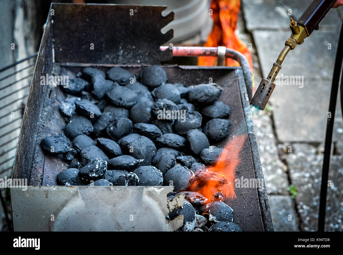 Firing up charcoal briquettes for the BBQ grill. Starting a grill with