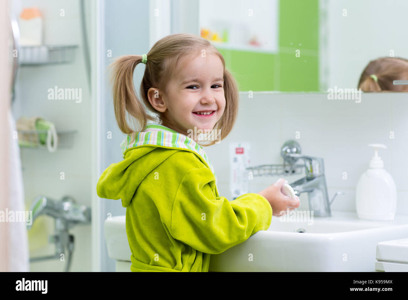 Kid girl is washing her hands with soap in the bathroom Stock Photo - Alamy