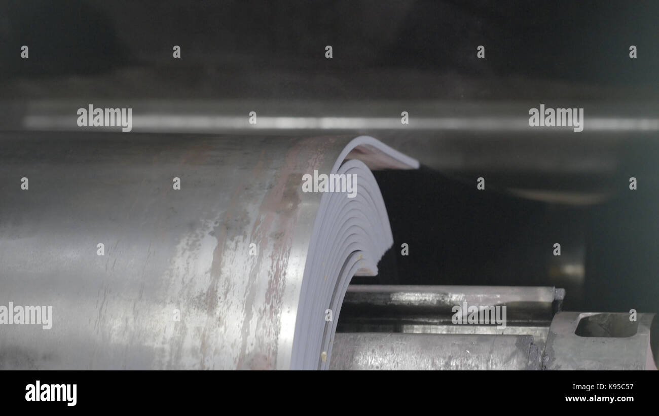 Metal tape is moving on rolling machine closeup. Rolling sheet rolling