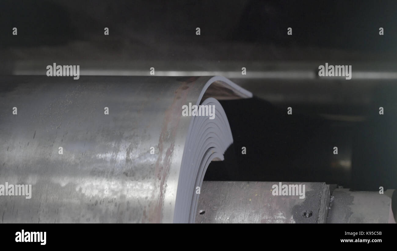 Metal tape is moving on rolling machine closeup. Rolling sheet rolling