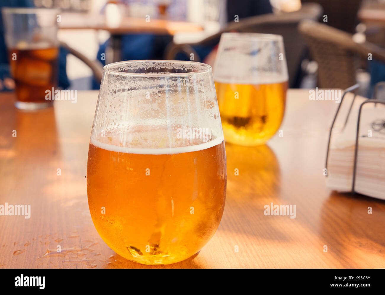 glasses of golden beer outdoor on table outdoor in a bar Stock Photo