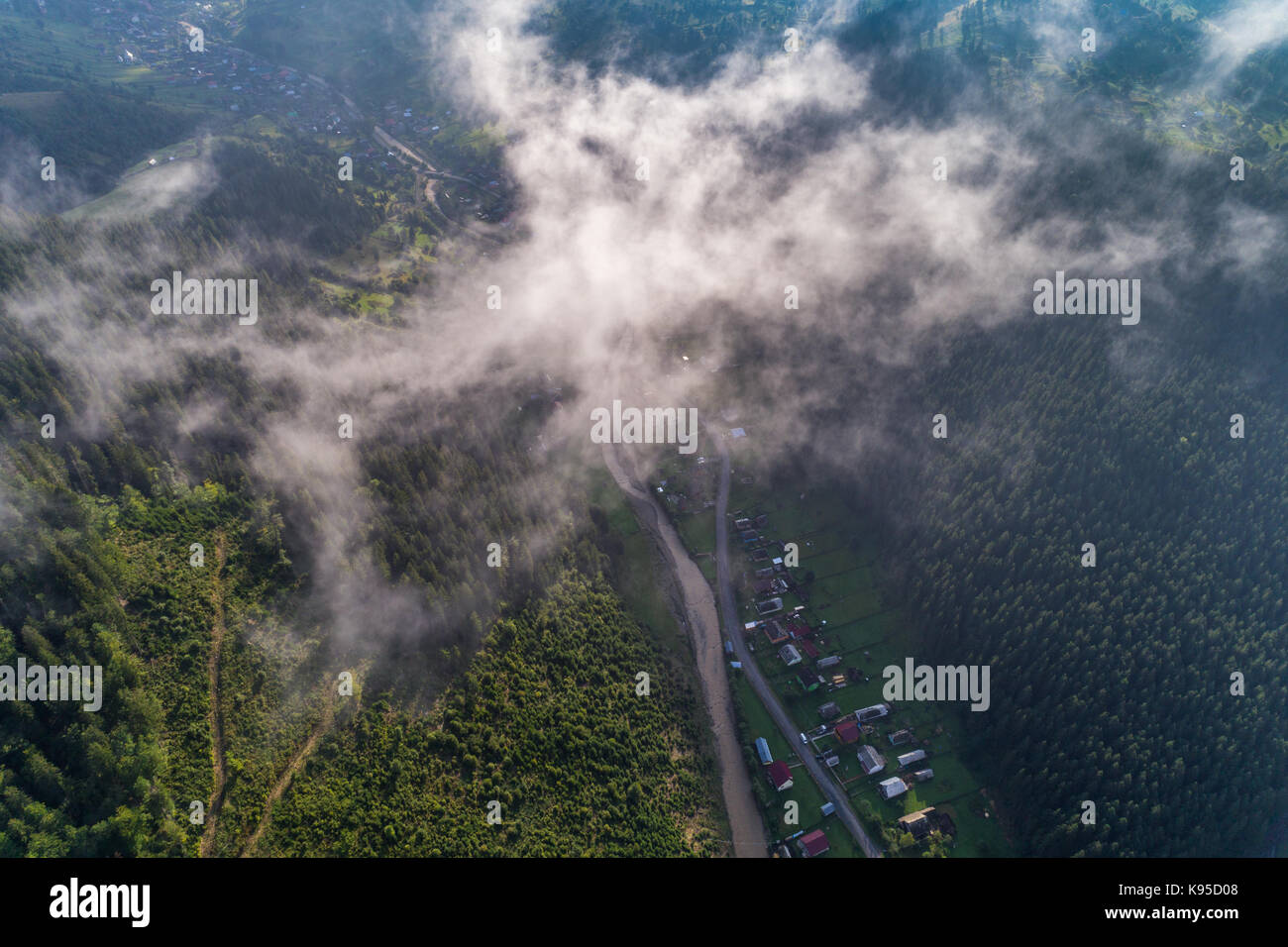 Aerial view of the village in the Carpathian mountains with clouds in ...