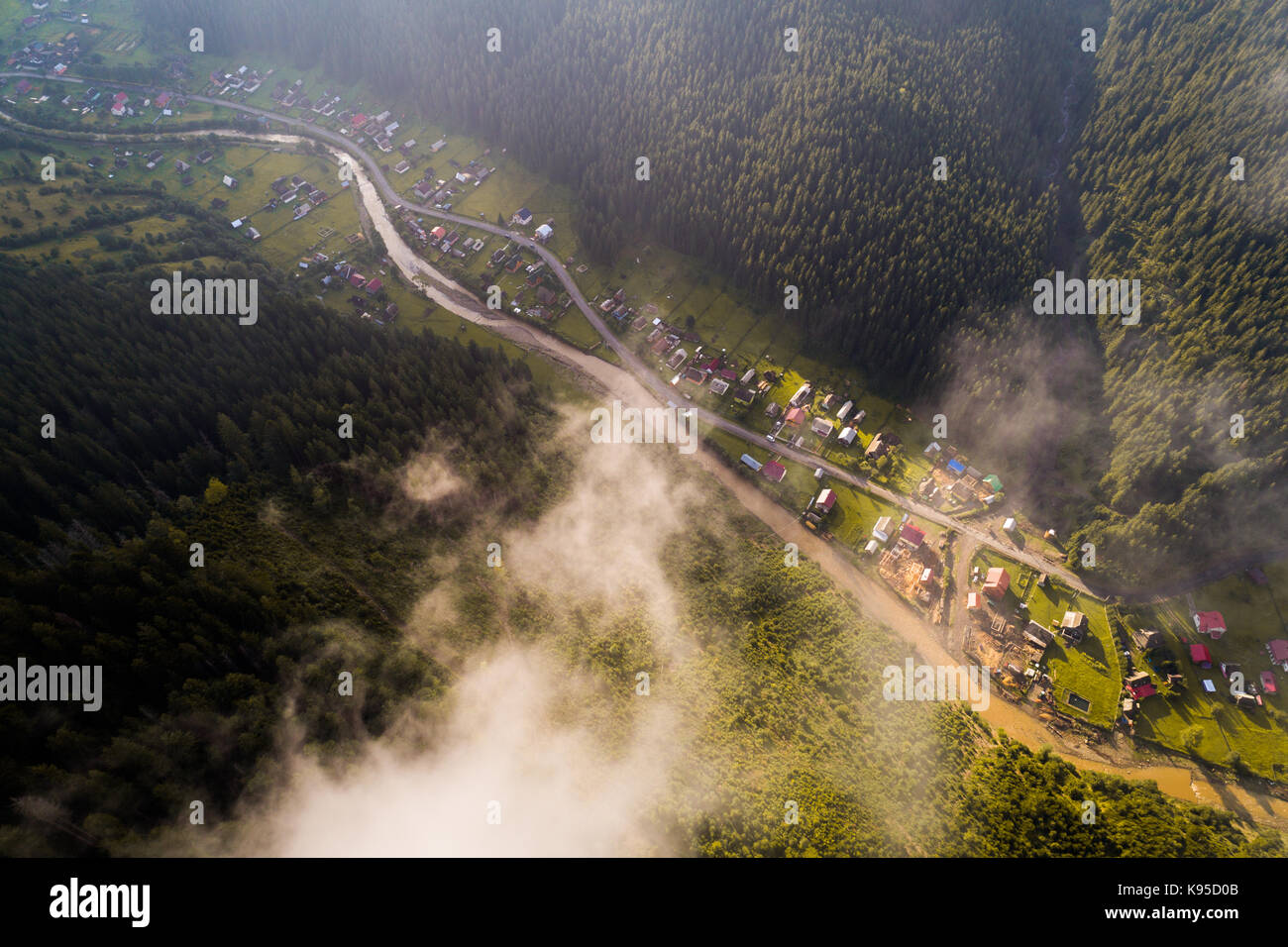 Aerial view of the village in the Carpathian mountains with clouds in ...