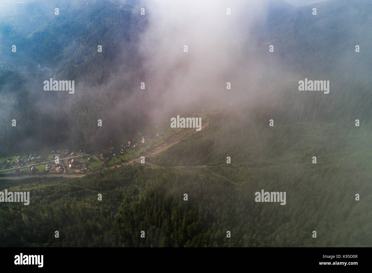 Aerial view of the village in the Carpathian mountains with clouds in ...