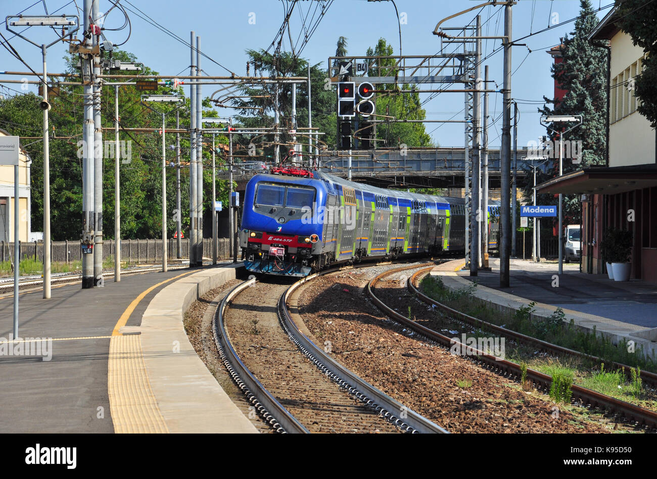 Class E464 electric locomotive heads a passenger train into the railway station, Modena, Italy Stock Photo