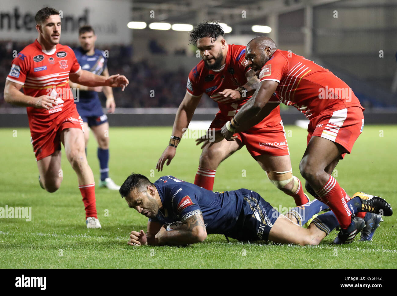 St Helens Zeb Taia goes over for a try past Salford Red Devils' Ben Murdoch-Masila (left) and Rob Lui (right), during the Betfred Super 8s match at the AJ Bell Stadium, Salford. Stock Photo