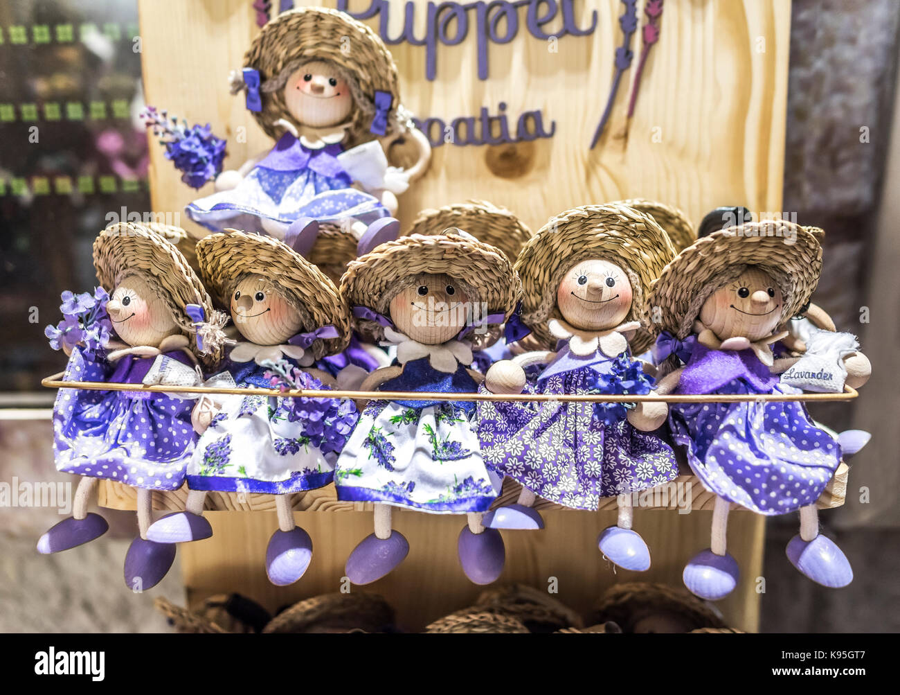 Wooden dolls dressed in purple outfits. Stock Photo