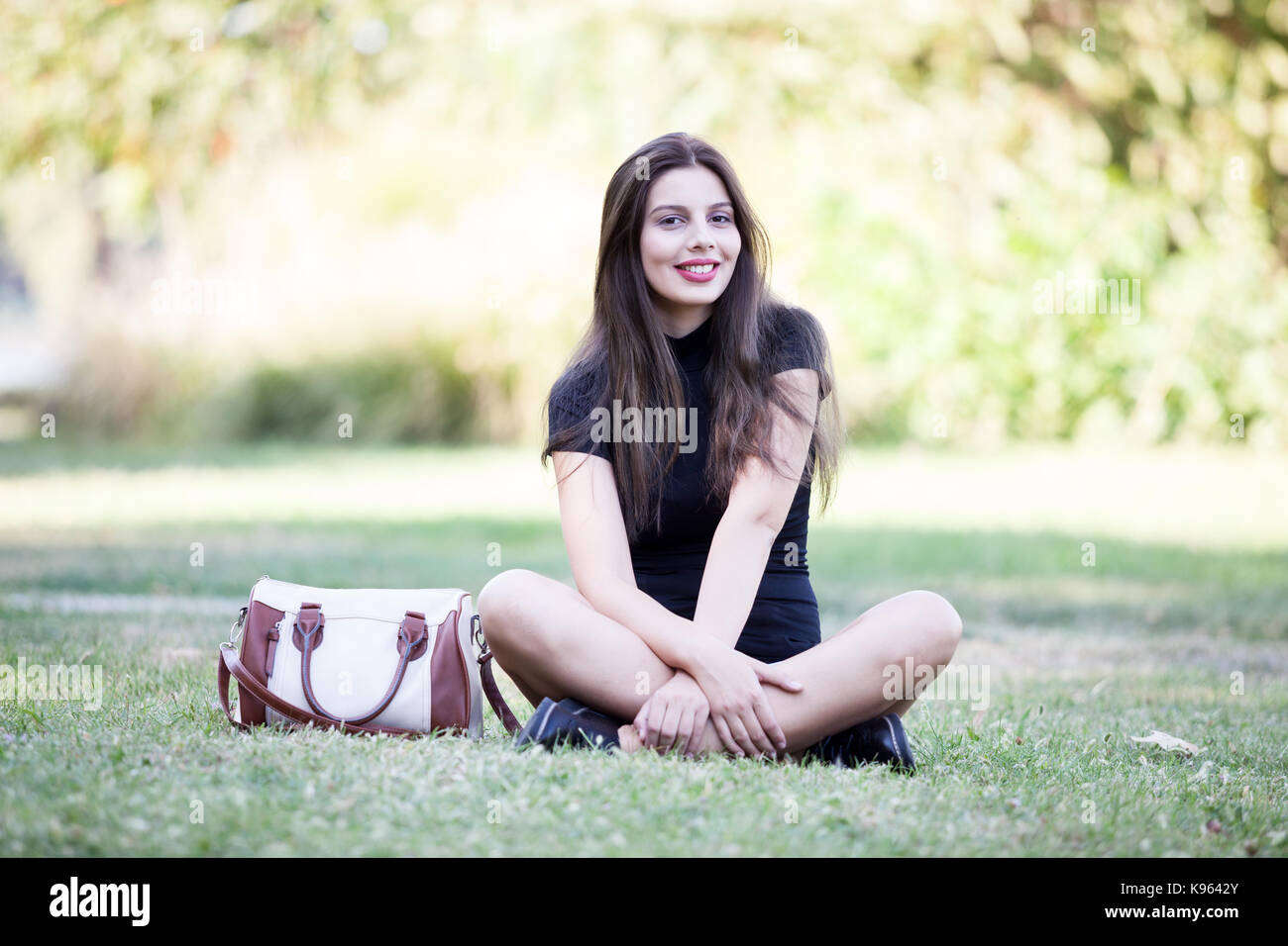 Pretty young woman posing in the park Stock Photo - Alamy