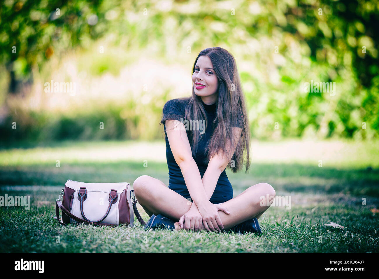 Pretty young woman posing in the park Stock Photo - Alamy