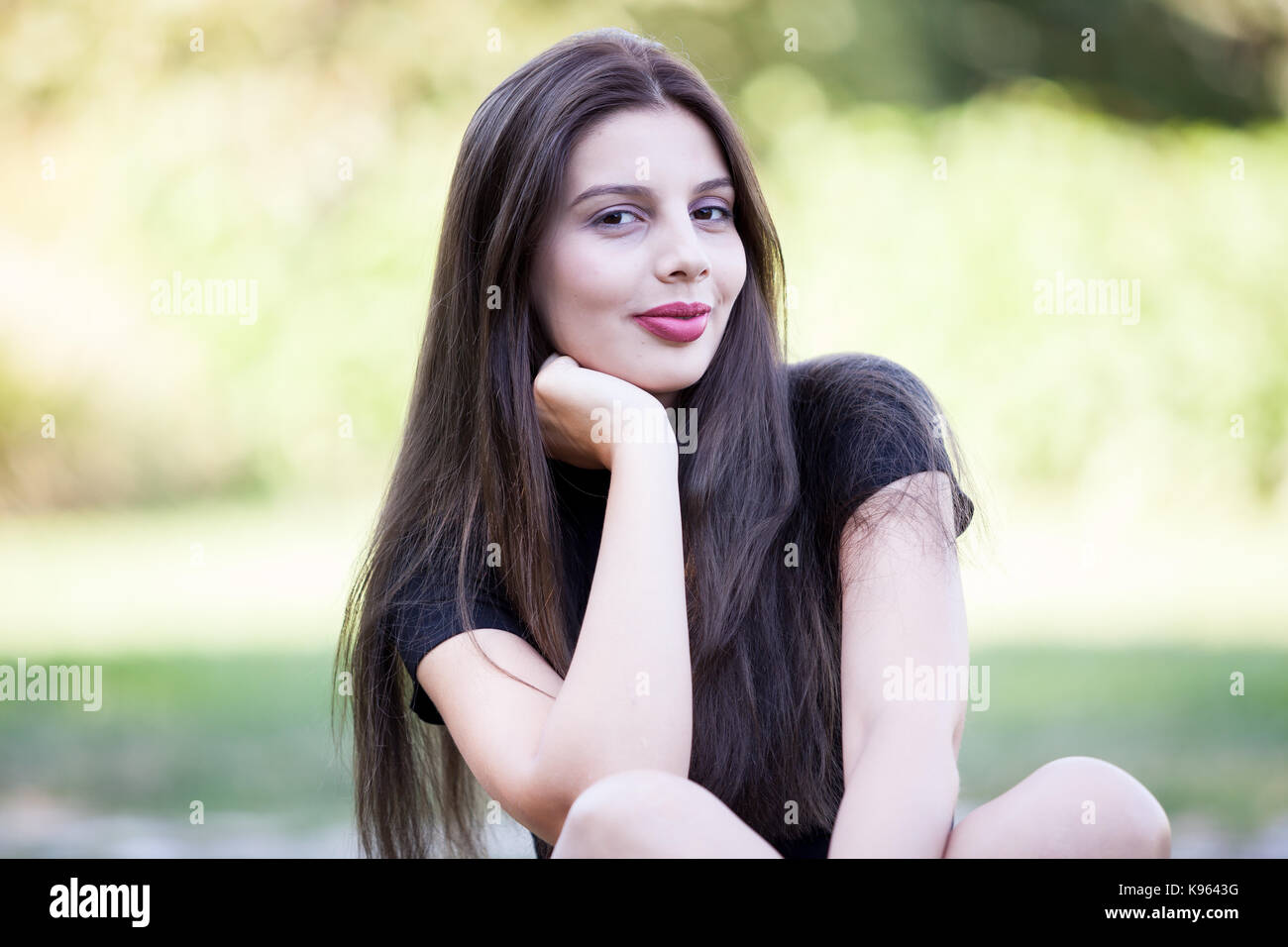 Pretty young woman posing in the park Stock Photo - Alamy