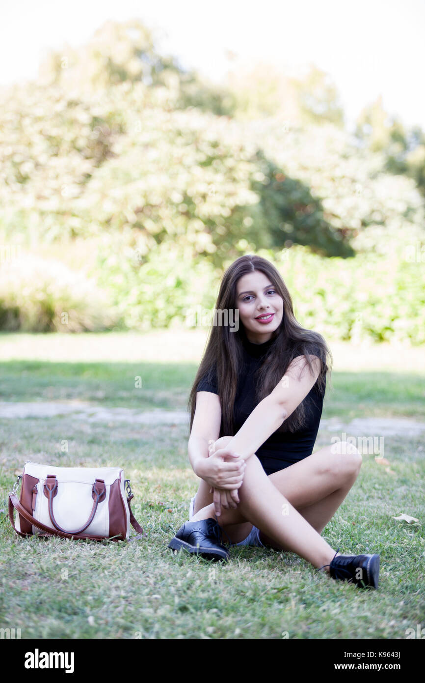 Pretty young woman posing in the park Stock Photo - Alamy