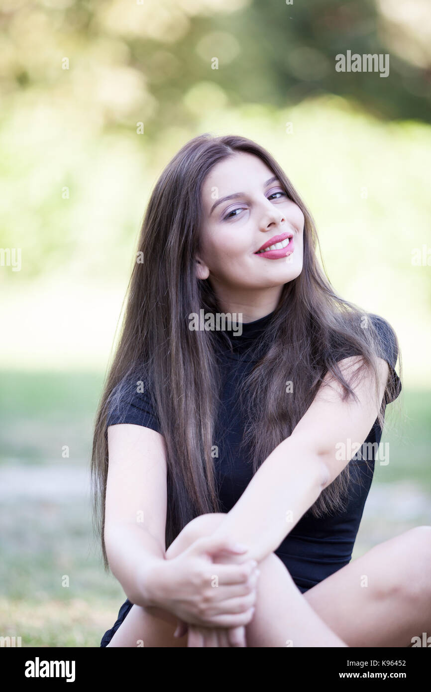 Pretty young woman posing in the park Stock Photo - Alamy
