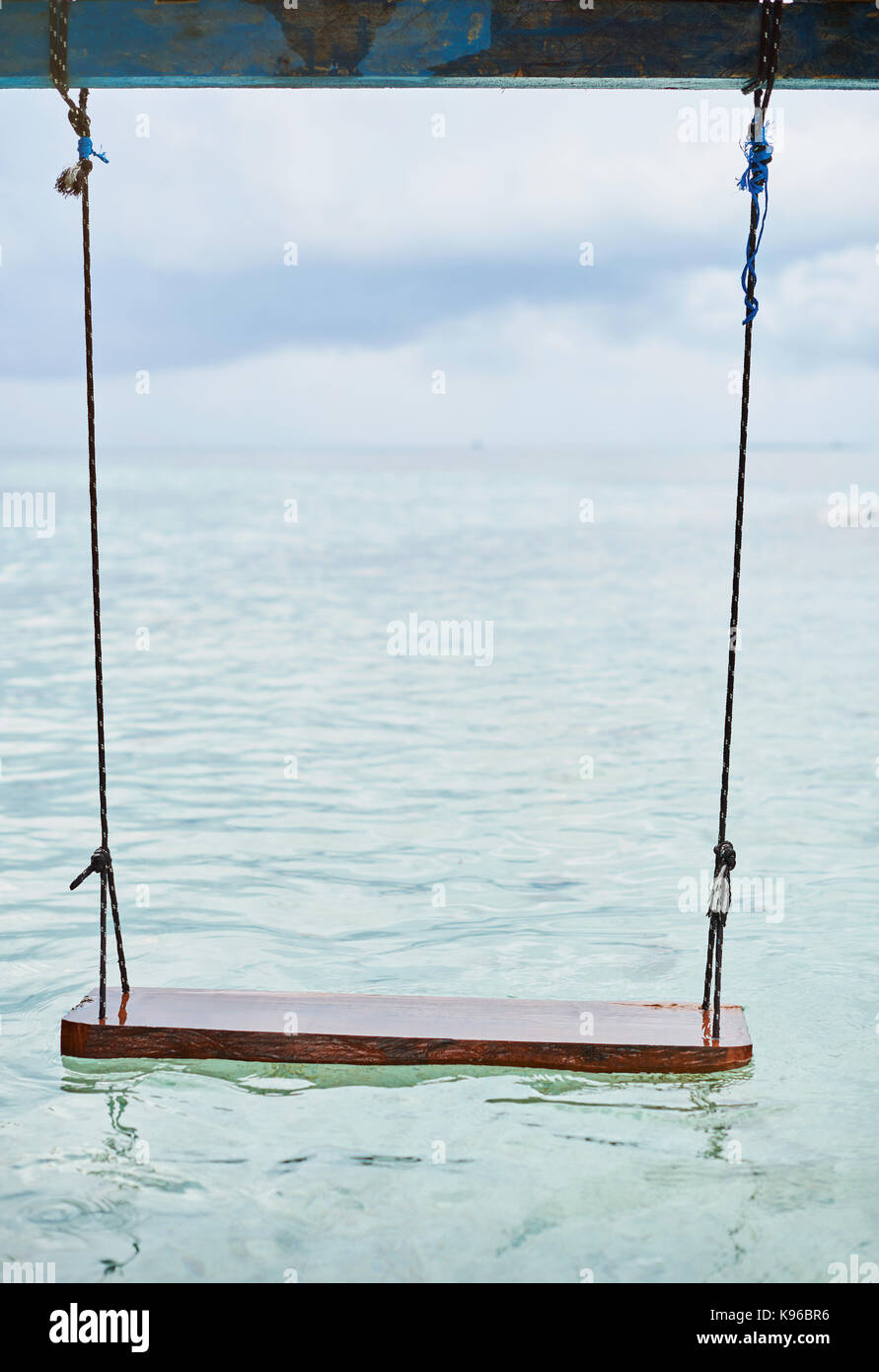 Wooden swings at sea water floating on cloud background Stock Photo - Alamy