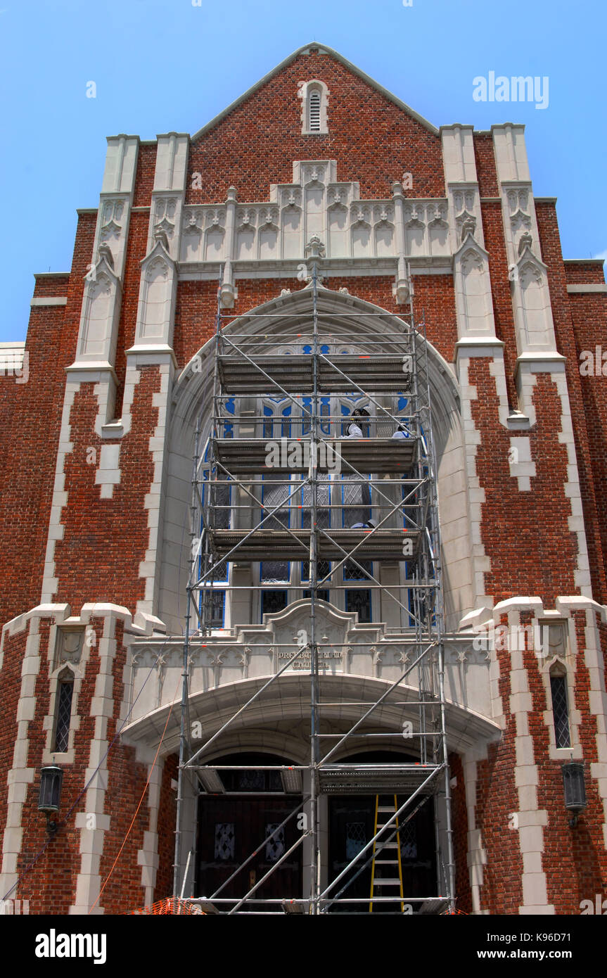 Workers stand on scaffolding to repaint fixtures around stained glass windows of the Cathedral of St. John Berchmans in Shreveport, Louisiana.  Tall s Stock Photo