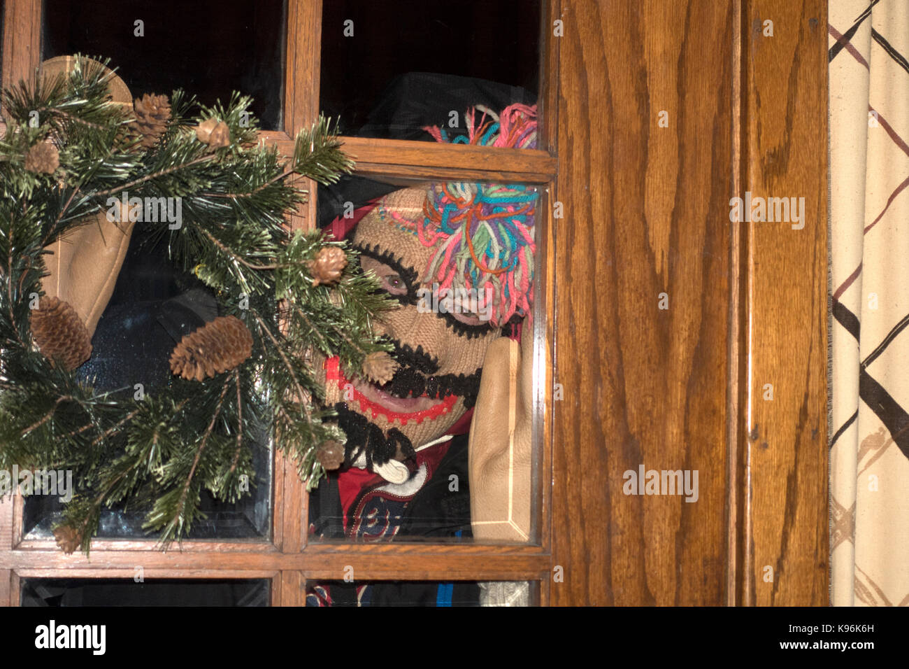 Infamous photographer Steve Skjold peering through door dressed in winter walking gear. St Paul Minnesota MN USA Stock Photo